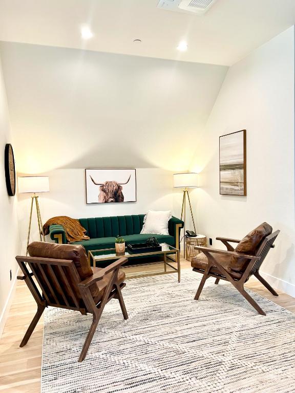 a living room with a green couch and two chairs at New Haven Inn in Solvang