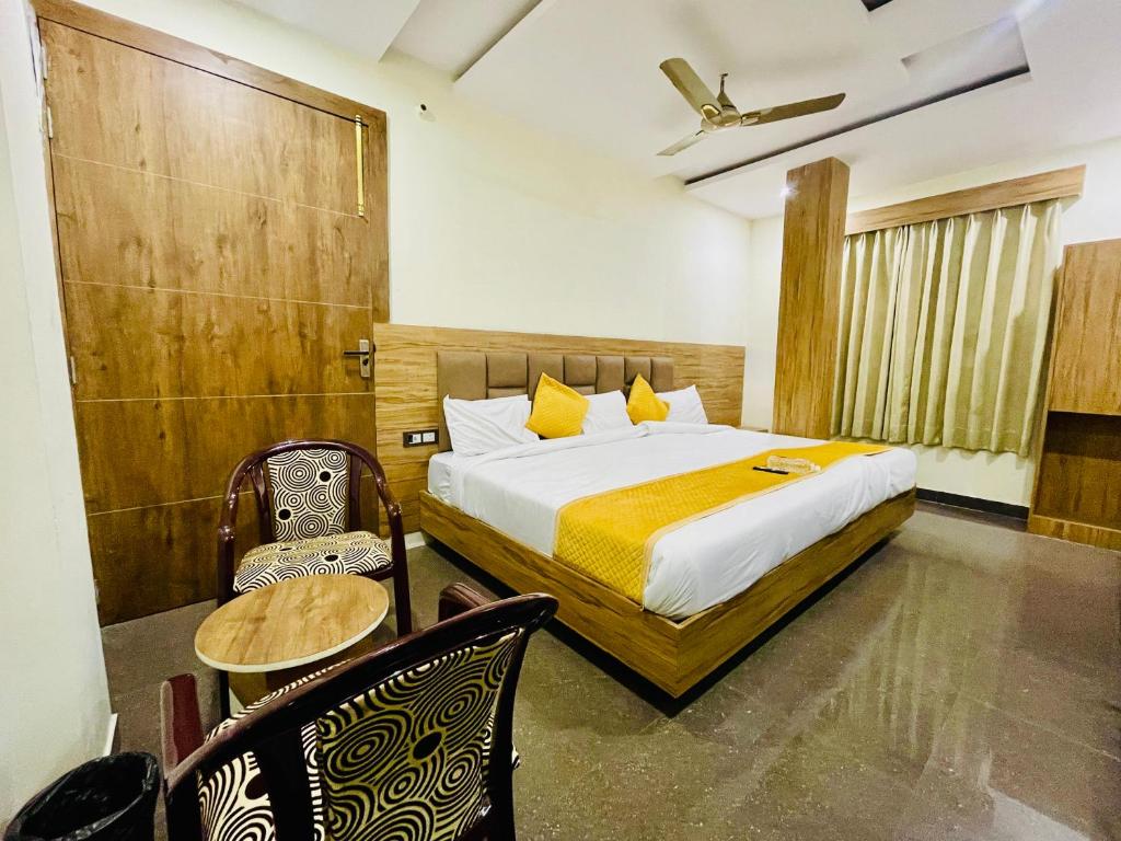 a bedroom with a bed and a table and chairs at Hotel Taj Star by Urban stay in Agra