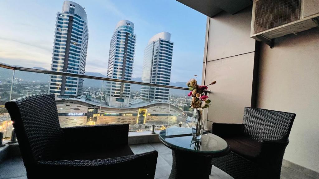 a balcony with a table and chairs and a view of tall buildings at Sky Heights Luxury Apartments Facing Centaurus Mall Islamabad in Islamabad