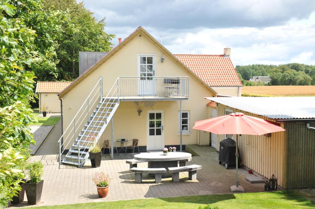 a house with a patio with a table and a staircase at Herning Bed & Breakfast in Herning