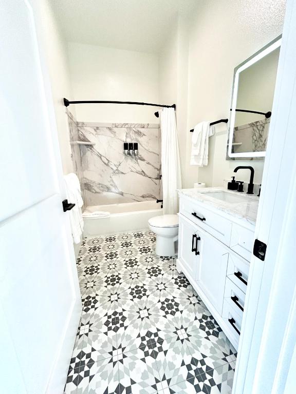 a white bathroom with a black and white tile floor at New Haven Inn in Solvang