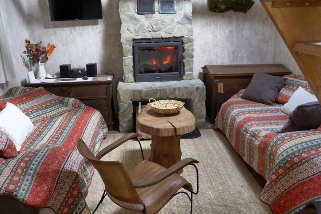 a living room with two beds and a stone fireplace at Anka in Gospić