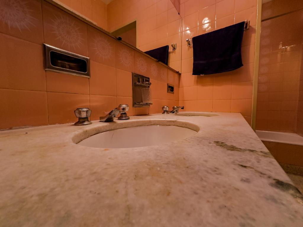 y baño con lavabo y espejo. en Rodex Hostel Tucuman en San Miguel de Tucumán