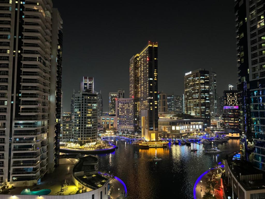 a city skyline at night with a river and buildings at Living Room JBR in Dubai