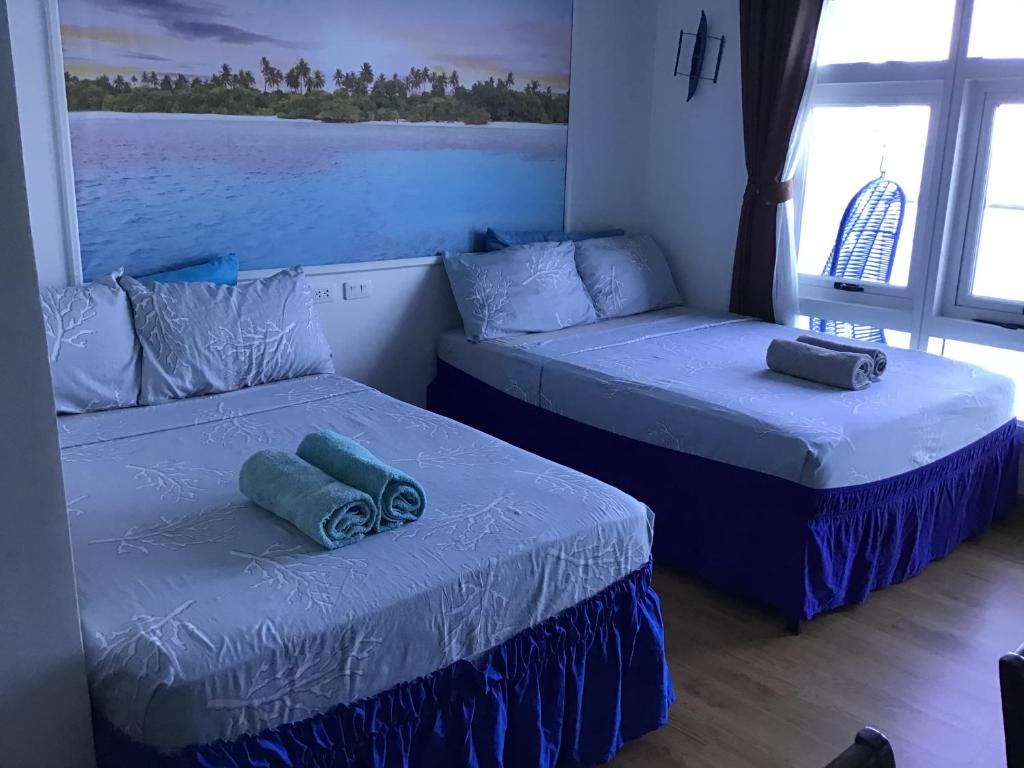 1 dormitorio con 2 camas y ventana en OceanFront at Arterra, fast WiFi, NFlix, kitchen - B or G en Isla de Mactán