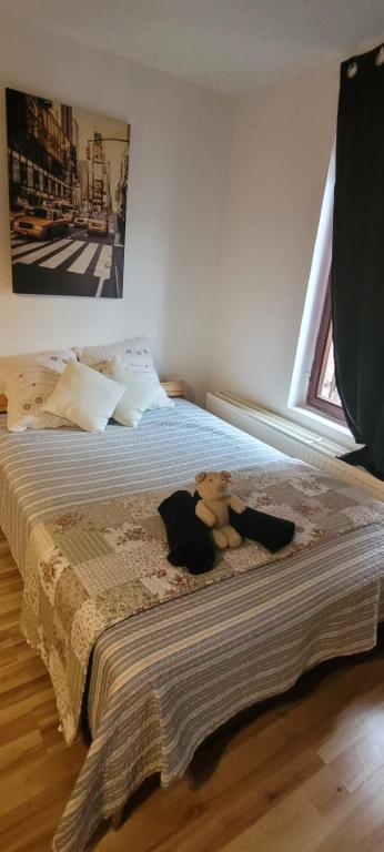 a teddy bear laying on a bed in a bedroom at Central Belgium in Brussels