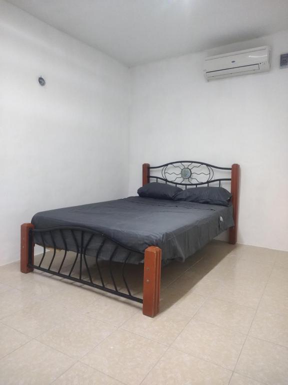 Departamento en Campeche estación del tren maya في كامبيش: غرفة نوم بسرير مع اطار معدني