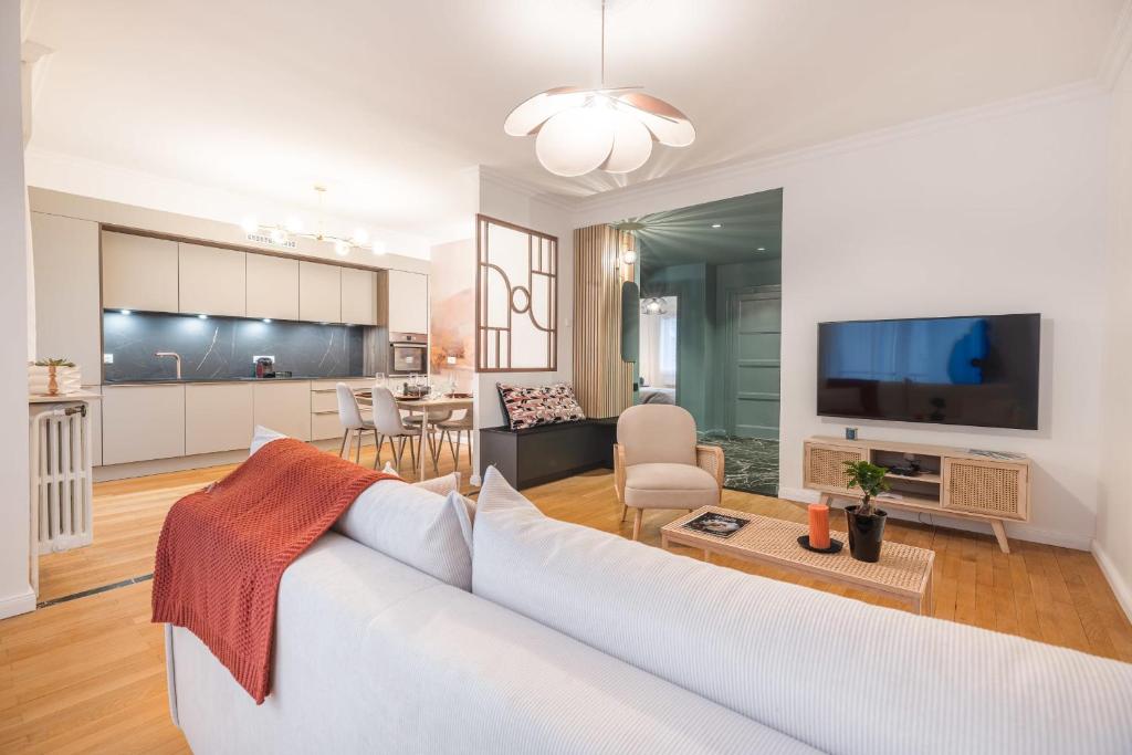 un salon avec un canapé blanc et une cuisine dans l'établissement Apartment - Le Bloom In the heart of Annecy, à Annecy