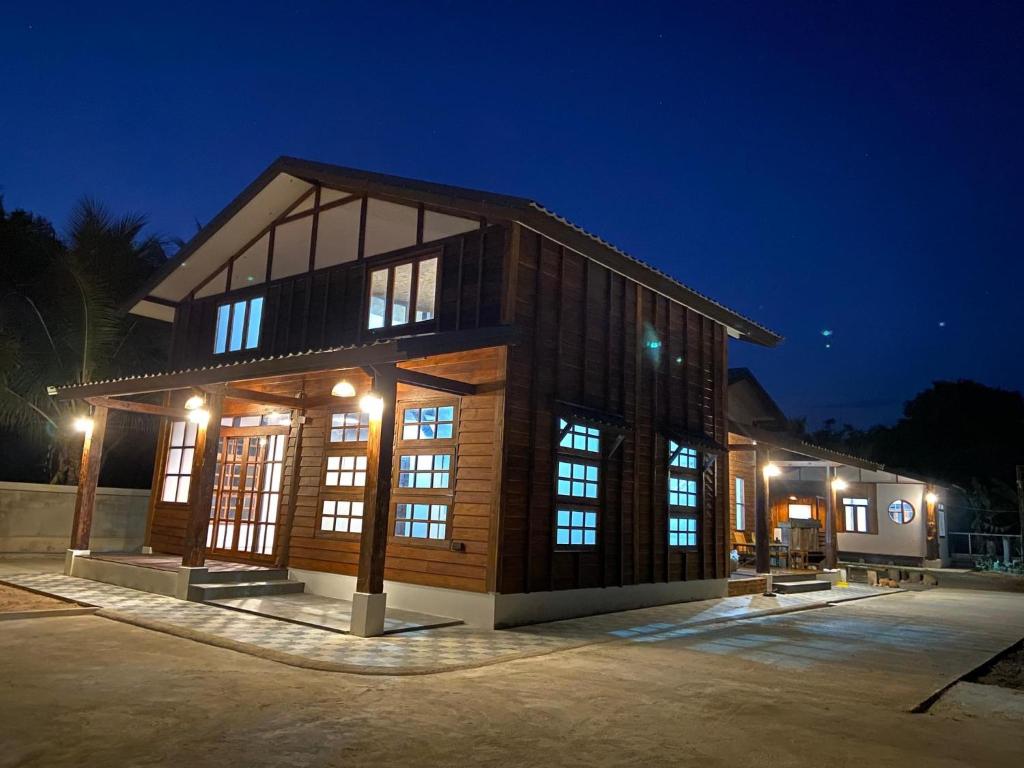 a large building with windows at night at บ้านฮิดะ หางดง in Ban Phae Khwang