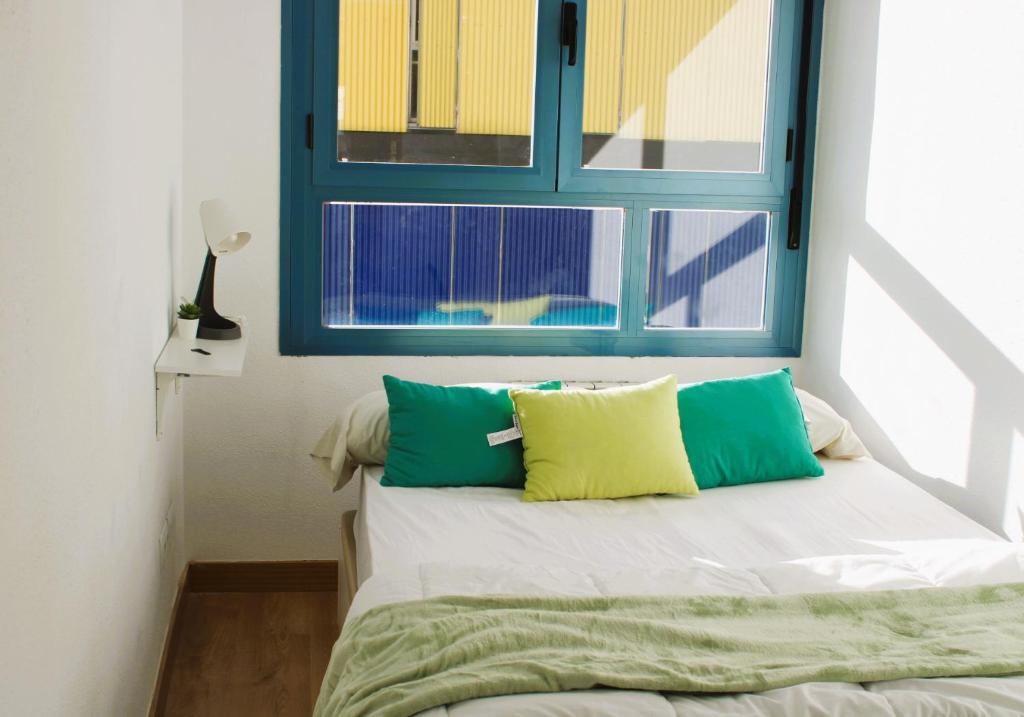 Habitación con cama y ventana azul en Reverdecer 2 en Madrid