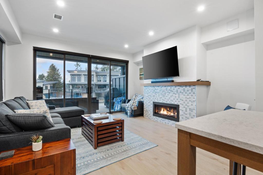 a living room with a couch and a fireplace at I Beach You To It! at THE BEACH HOUSE in Campbell River