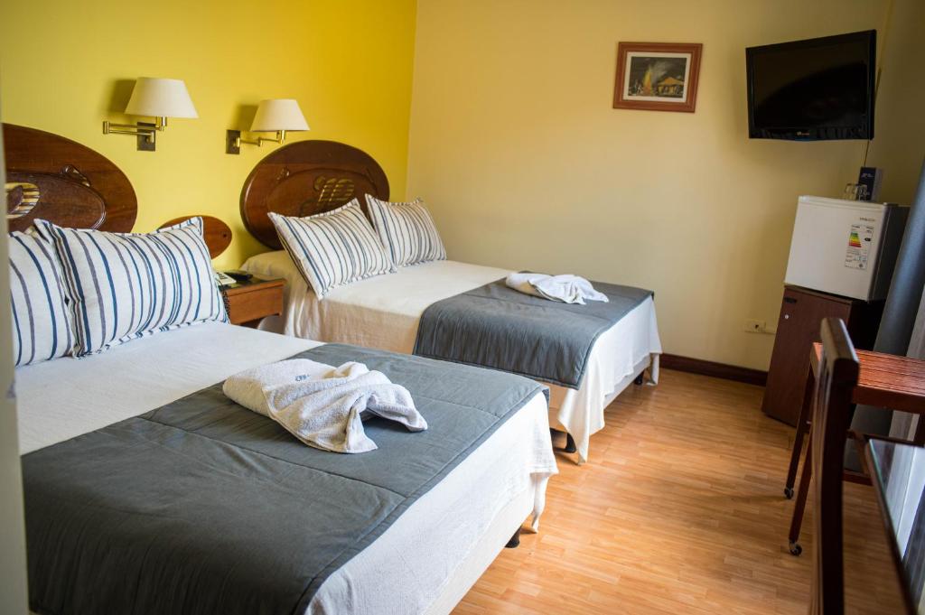 a hotel room with two beds and a couch at Gran Hotel Presidente in Salta