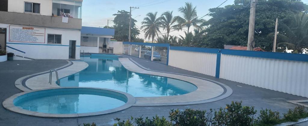 a swimming pool in front of a building at Cantinho dos sonhos in Piúma