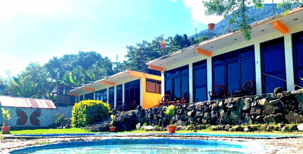una casa con piscina frente a ella en Hotel Porto Bello en San Pedro La Laguna