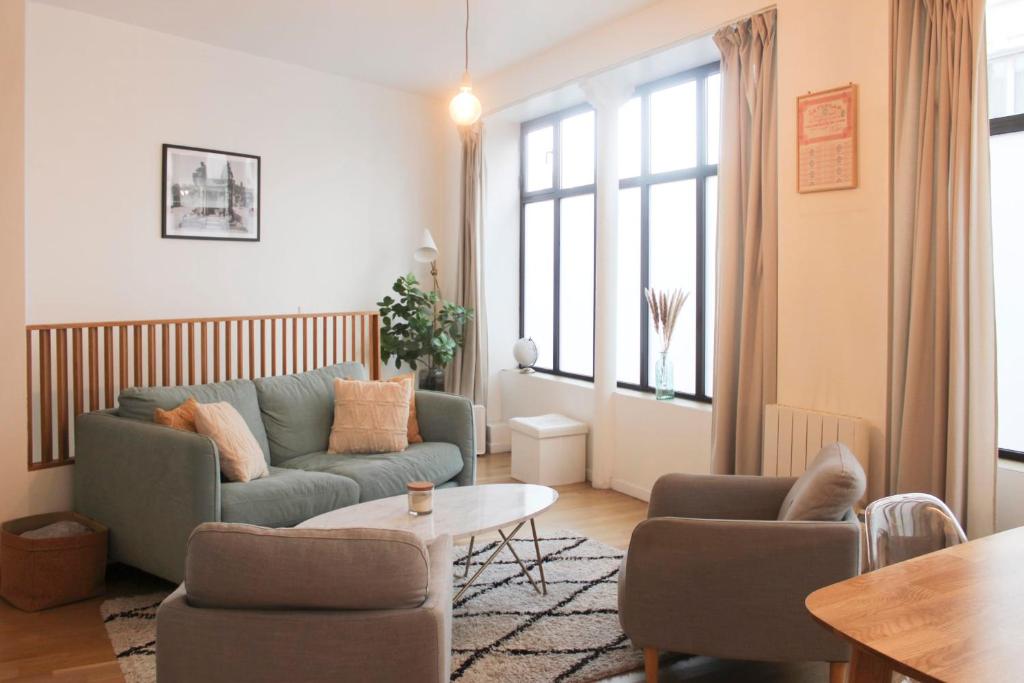 een woonkamer met een bank en een tafel bij Pretty cocoon 2 steps from Montmartre in Parijs