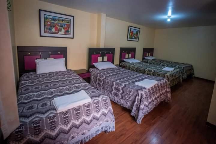 een kamer met drie bedden in een kamer bij HOTEL VILLA HERMOSA in Yanque