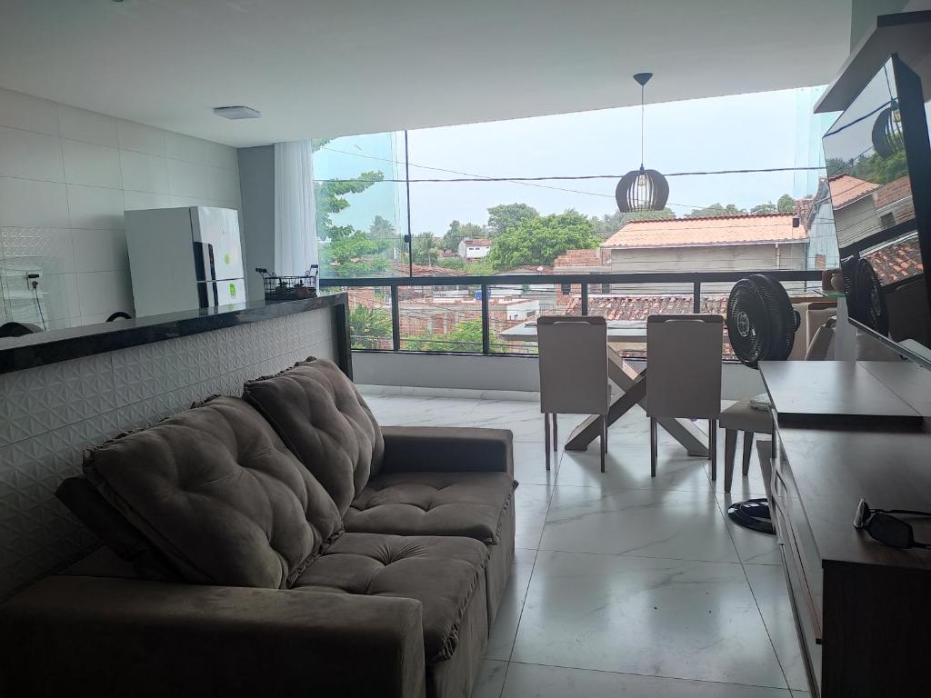 ein Wohnzimmer mit einem Sofa und einem Tisch in der Unterkunft Apartamento Brisa da Ilha in Cayru