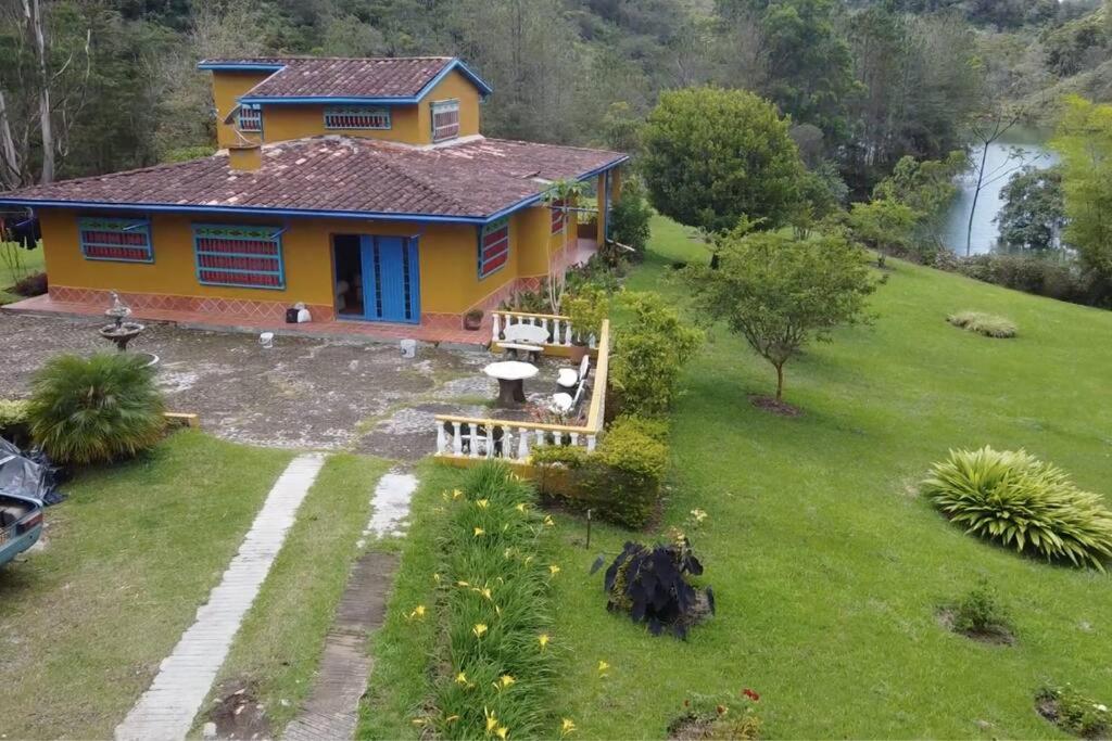 an aerial view of a yellow house with a yard at La Escondida, con acceso al lago in Guatapé