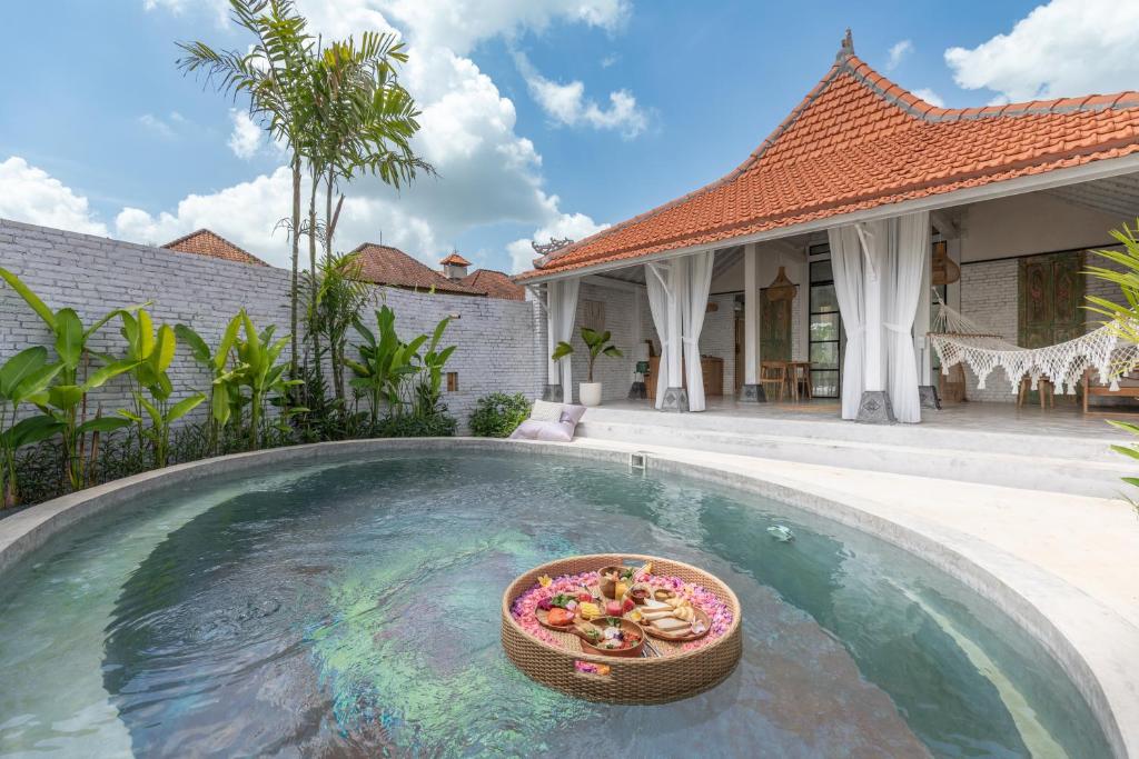 a bowl of food in a pool in front of a house at Sanctuary Villas in Ubud