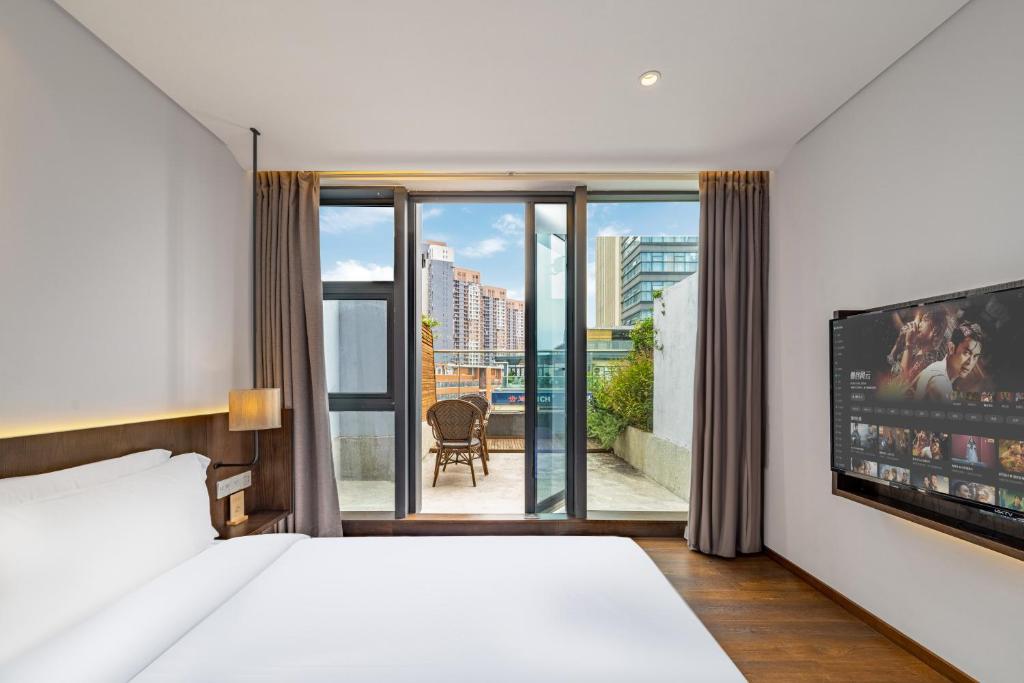 重庆Wuyu Hotel - Chongqing Jiangbei Airport & Light Rail的一间酒店客房,配有一张床和一台电视