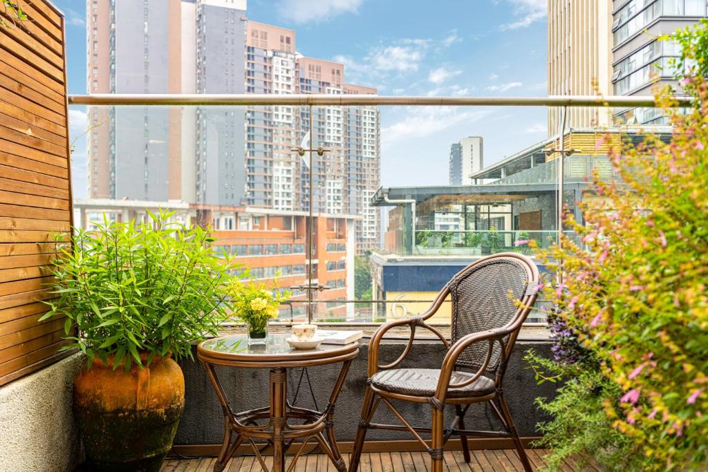 a balcony with two chairs and a table and a window at Wuyu Hotel - Chongqing Jiangbei Airport & Light Rail in Chongqing