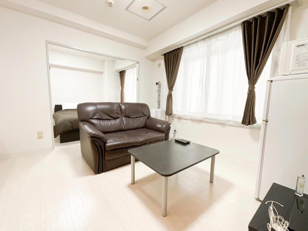 a living room with a leather chair and a table at E-Horizon Kita 2 Jo Building - Vacation STAY 15838 in Sapporo