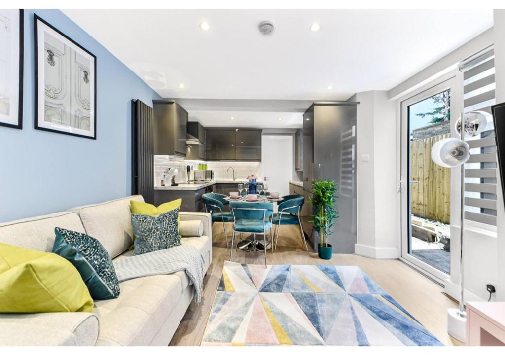 uma sala de estar com um sofá e uma mesa em Tranquility in Bloom: Refreshing 2BR Apartment em Londres