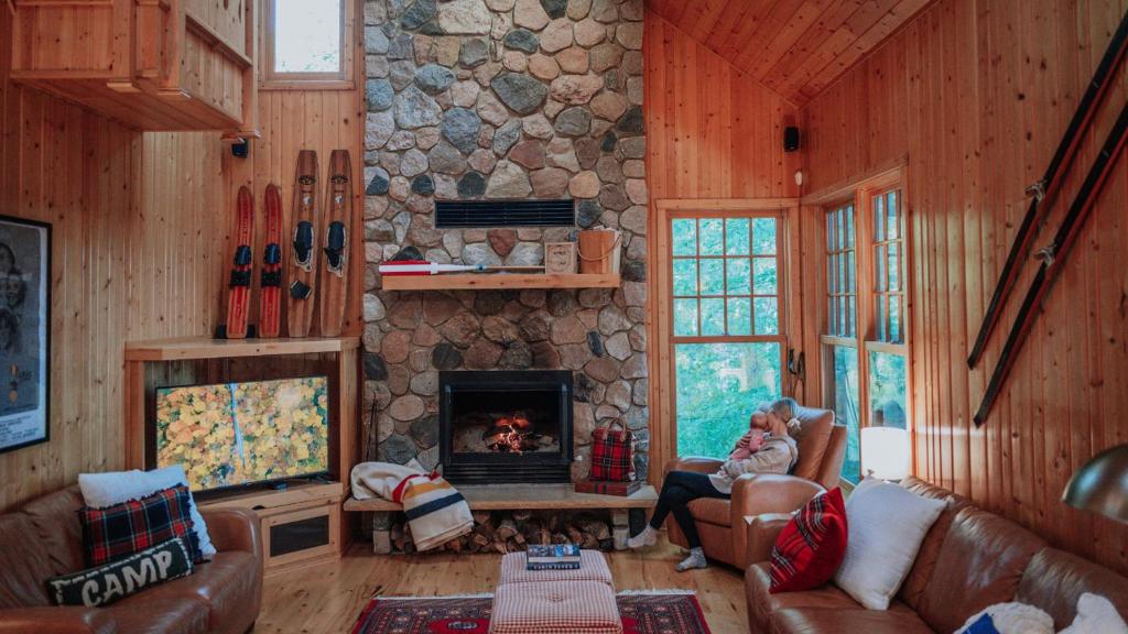 ein Wohnzimmer mit einem Steinkamin in einer Hütte in der Unterkunft Shady Pines On Kimble Lake in Pequot Lakes