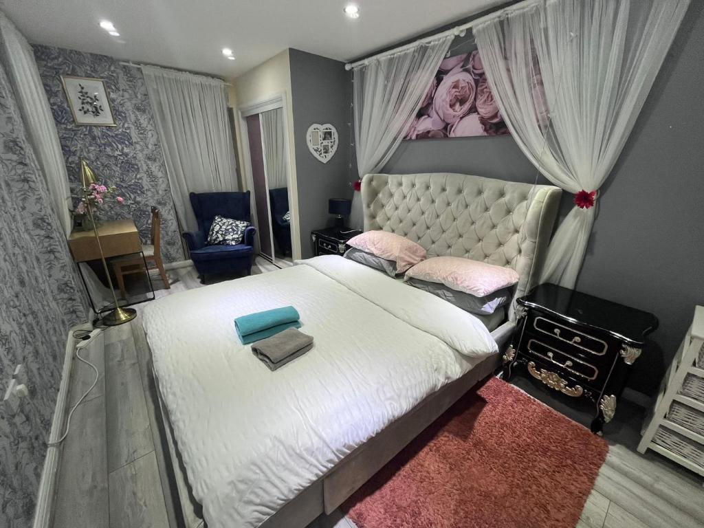 - une chambre avec un grand lit blanc et une grande tête de lit dans l'établissement Rooms near Canary wharf, à Londres