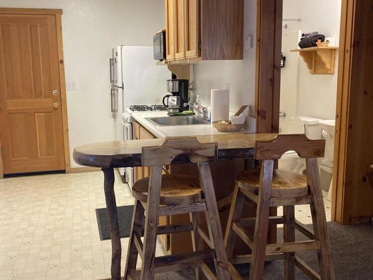 a kitchen with a counter with stools and a sink at 2410 - Oak Knoll Duplex Studio #12 cabin in Big Bear Lake