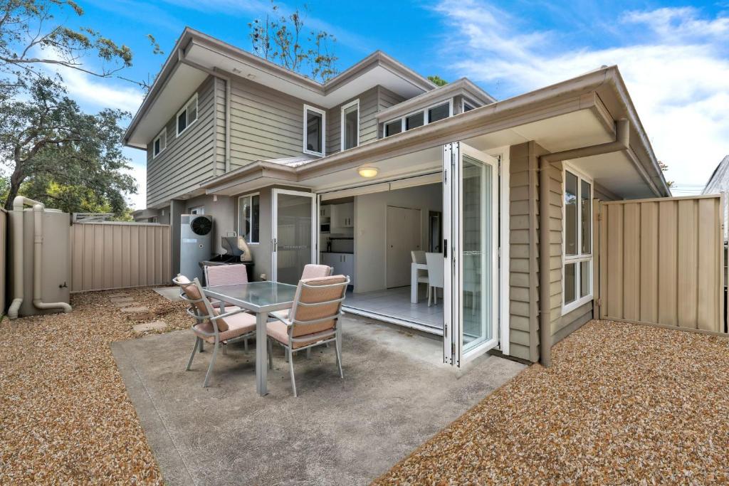 a small house with a glass table and chairs at Annvilla - Two bedroom townhouse in Huskisson in Huskisson