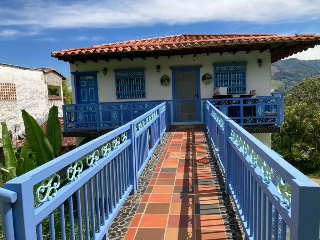 a blue bridge leading to a house with a blue door at Apartahotel Villa Carolina 4 in Jericó