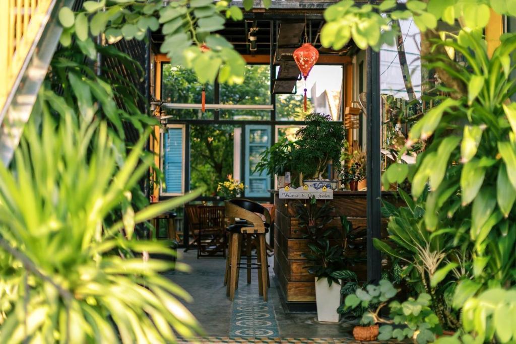 een restaurant met planten en een tafel en stoelen bij Trại Hoa Vàng Homestay at Tuy Hòa Phú Yên in Ðông Tác (1)