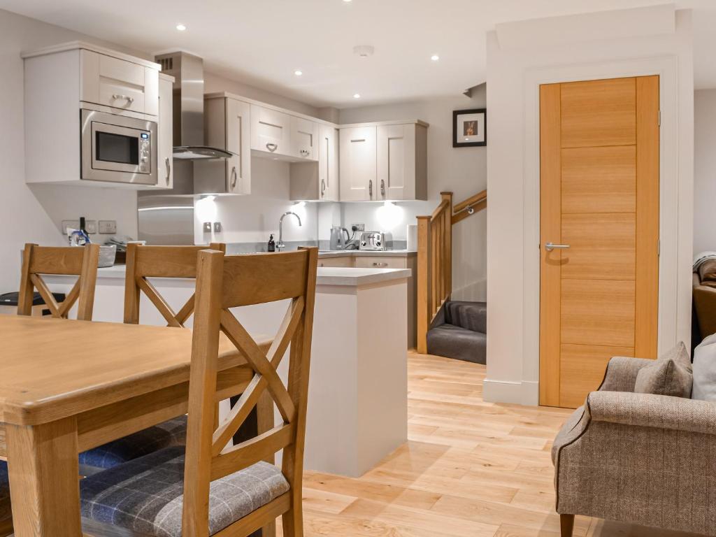 een keuken en een woonkamer met een tafel en stoelen bij Pride Of Erin - Uk45929 in Linlithgow