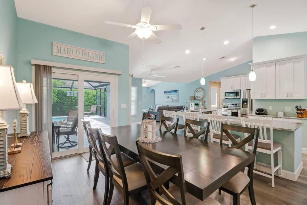 マルコ・アイランドにあるStunning 4BR Beach House - Pool - Spa - Near the Parkのテーブルと椅子のあるキッチンとダイニングルーム