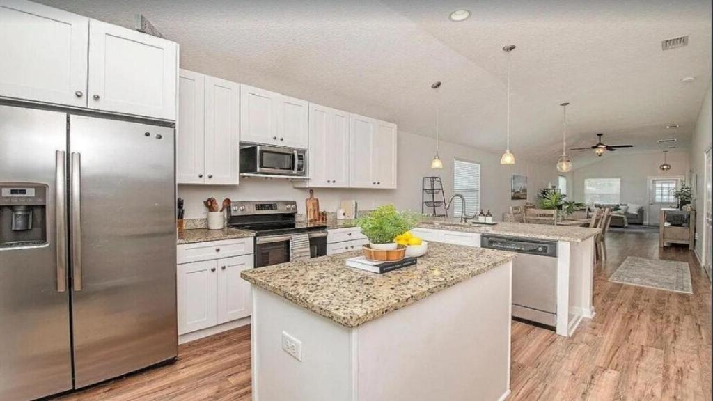 a kitchen with white cabinets and a stainless steel refrigerator at 2 St Augustine in St. Augustine