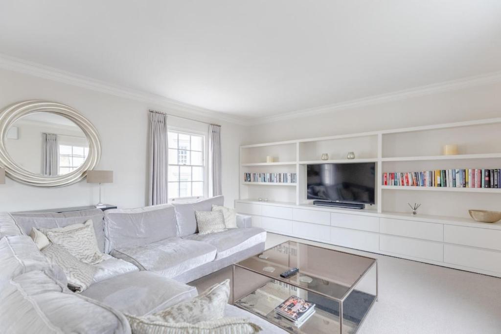uma sala de estar branca com um sofá branco e uma televisão em Luxurious 3BD Flat - Sloane Square Chelsea! em Londres