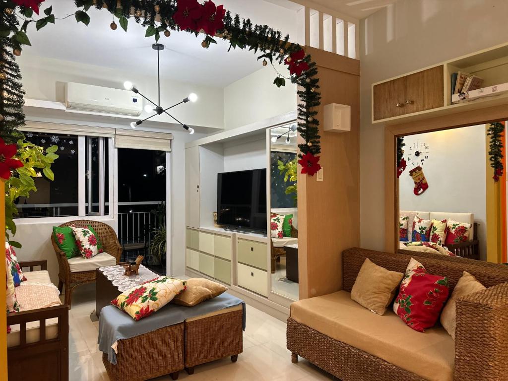 a living room with a couch and chairs and a television at Tagaytay Family Staycation Spacious 2 Unit Condo Sleeps 5 to 7 in Tagaytay