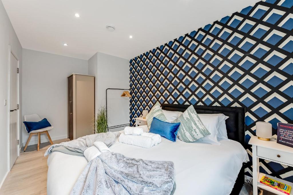 a bedroom with a large white bed with blue accents at Bright and Relaxing One Bedroom Flat in London