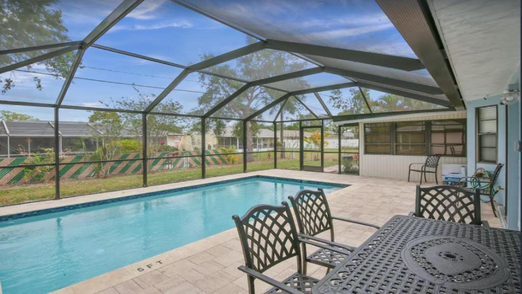 una piscina con tavolo e sedie accanto di 6795 Sarasota a Sarasota