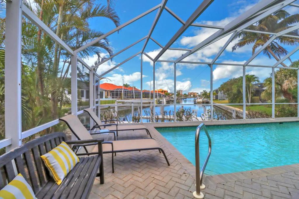 a pool at a resort with benches and a swimming pool at 80 Marco Island in Marco Island