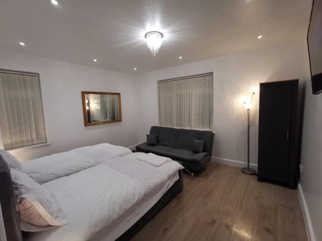 una camera con letto, divano e luce di Three Bedroom Modern Apartment by Luton Airport and Luton Station a Luton