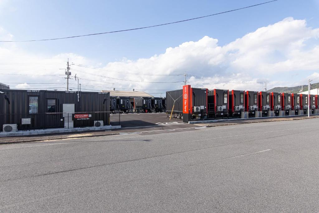 a row of train cars parked on the side of a road at HOTEL R9 The Yard 柳井 