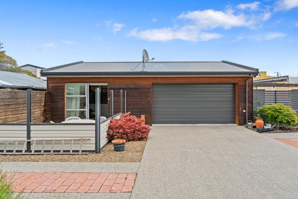 une maison avec un garage en face dans l'établissement Dicks Place - Alexandra Holiday Home, à Alexandra