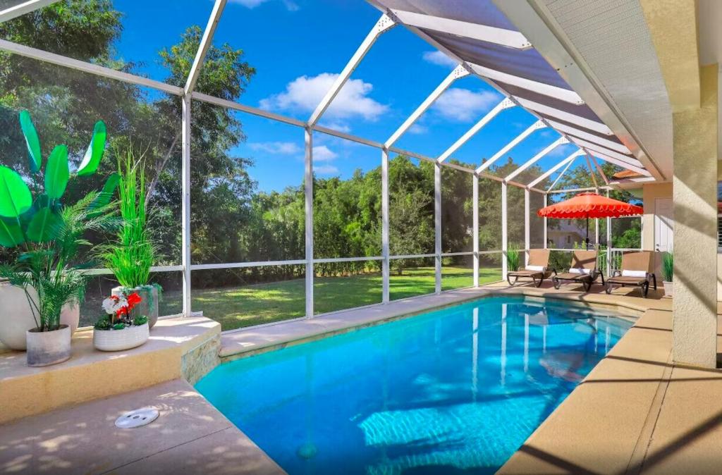 a swimming pool in a house with a large window at 4BR Beach House Private Pool Minutes to Beach in Marco Island