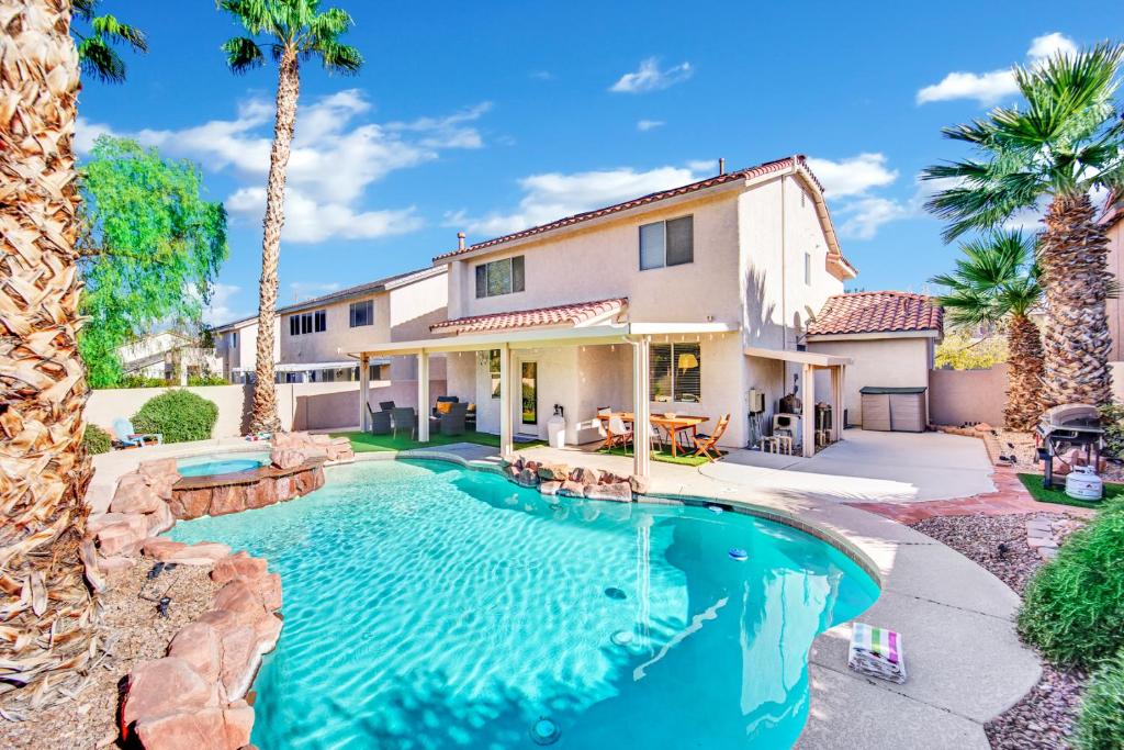 a house with a swimming pool and palm trees at Seven Palms in Henderson