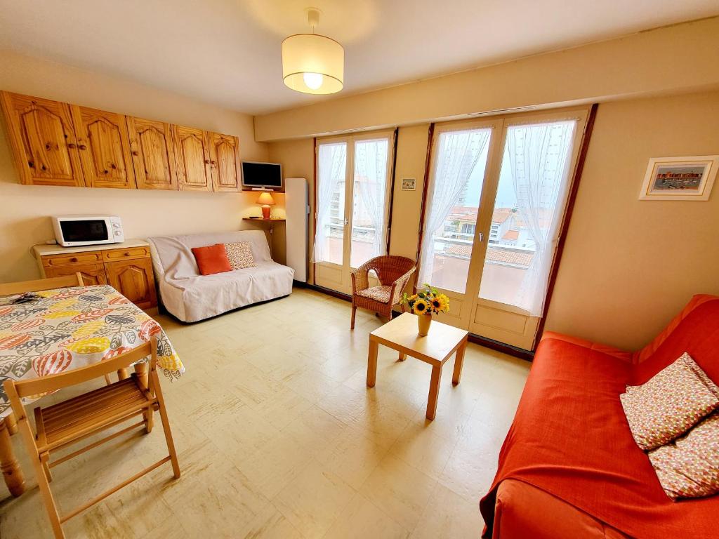 un salon avec un canapé rouge et une table dans l'établissement Studio charmant proche plage, chenal, et commerce, bien équipé au cœur des Sables d'Olonne - FR-1-92-597, à Les Sables-dʼOlonne