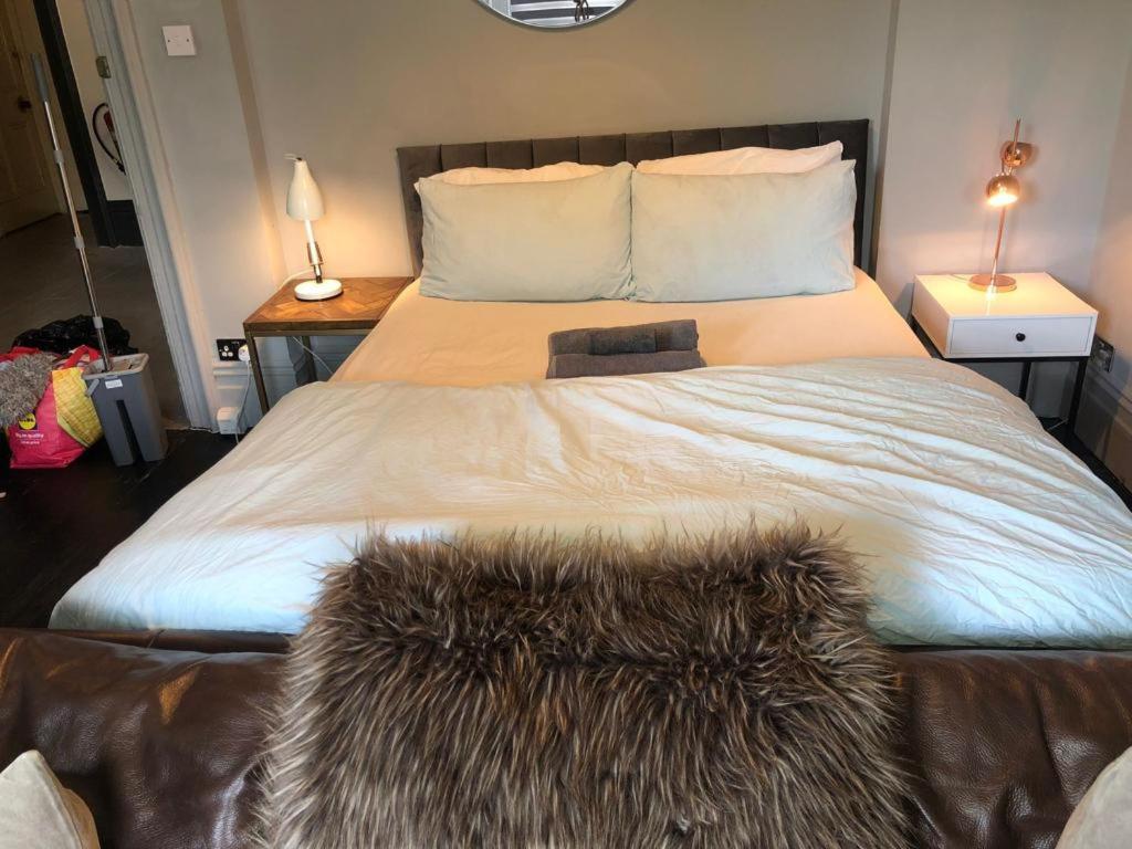 a bedroom with a large bed with a furry blanket at 10 Large Elegant Studio - Prime Location - Comfortable - Private in Brighton & Hove