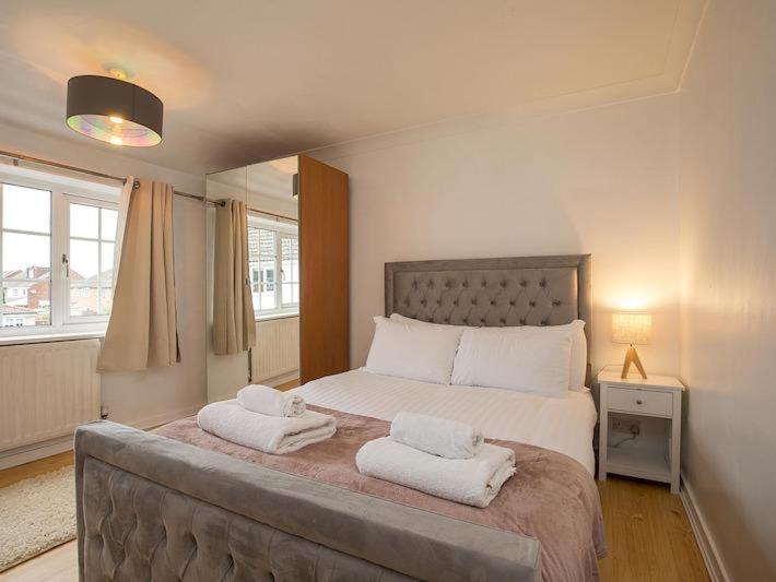 una camera da letto con un grande letto con due asciugamani di HAVEN VALLEY a Old Windsor