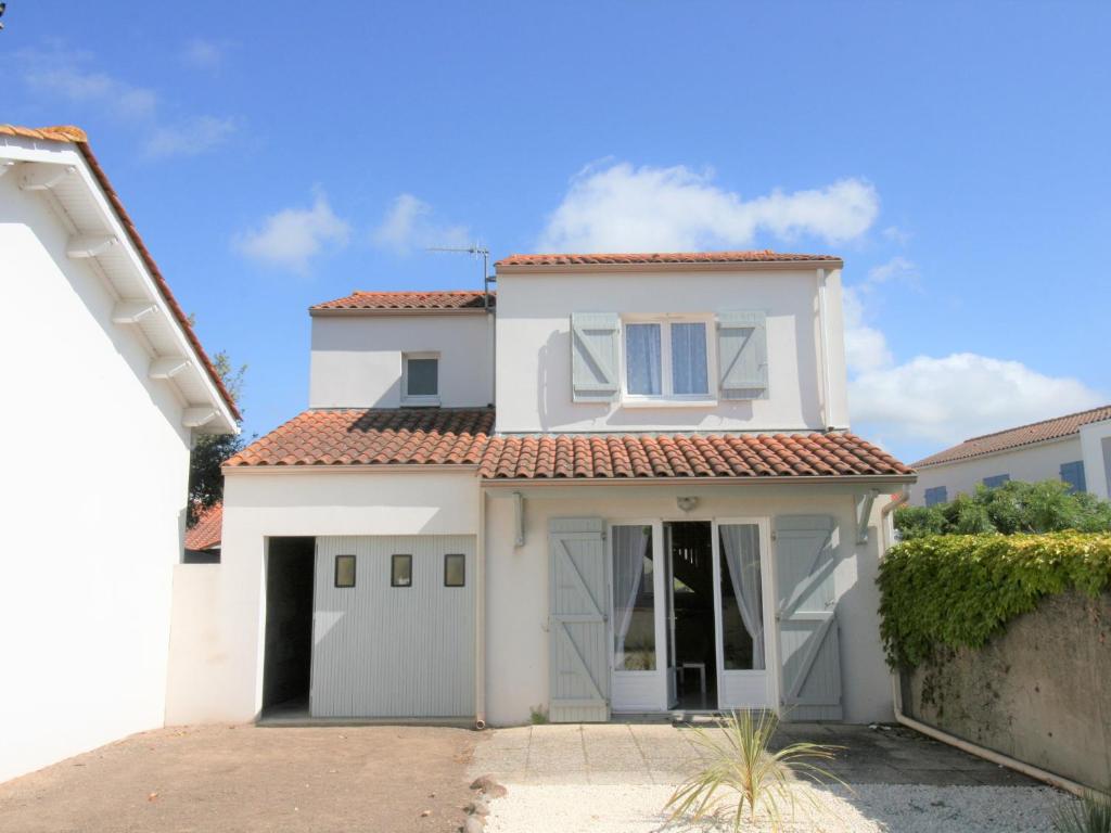 une maison blanche avec un garage dans l'établissement Maison rustique au centre-ville, proche plage, avec jardin et 3 chambres ! - FR-1-22-223, à La Tranche-sur-Mer